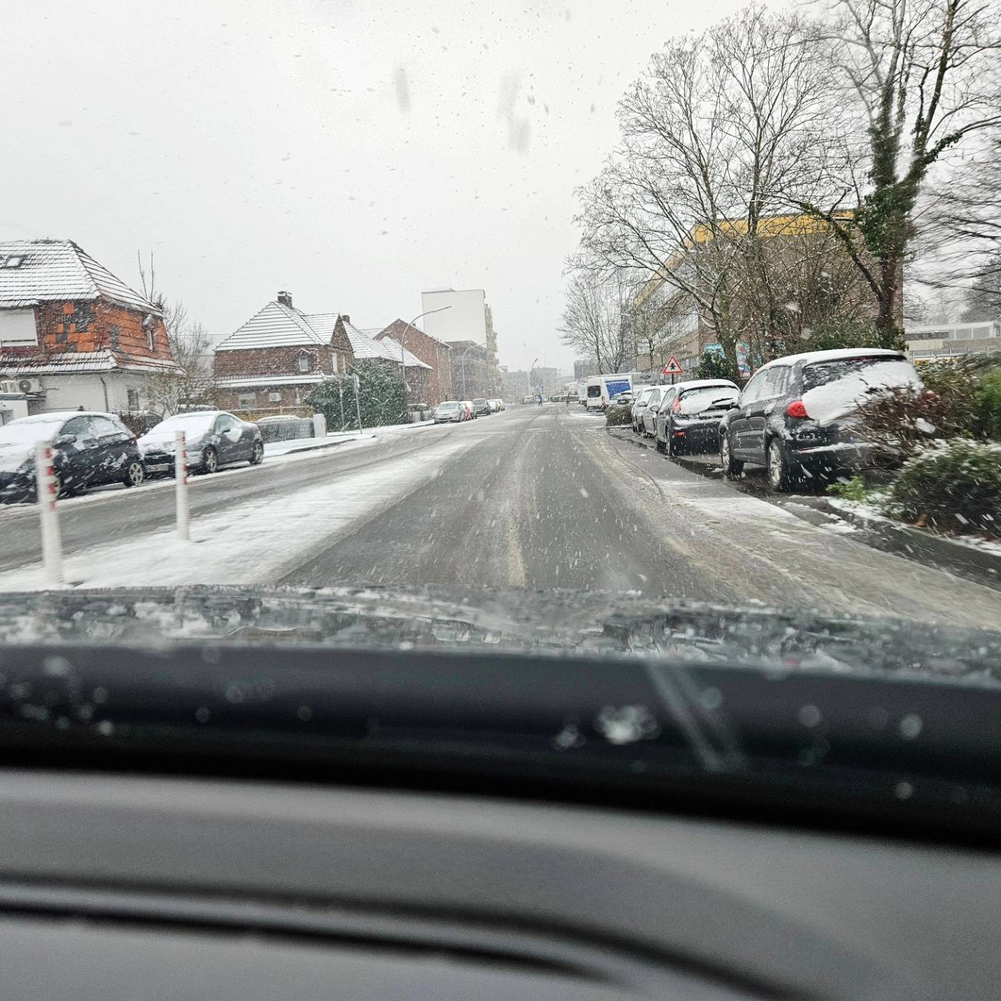 Eine winterliche, schneebedeckte Straße, aus dem Fahrzeug raus fotografiert